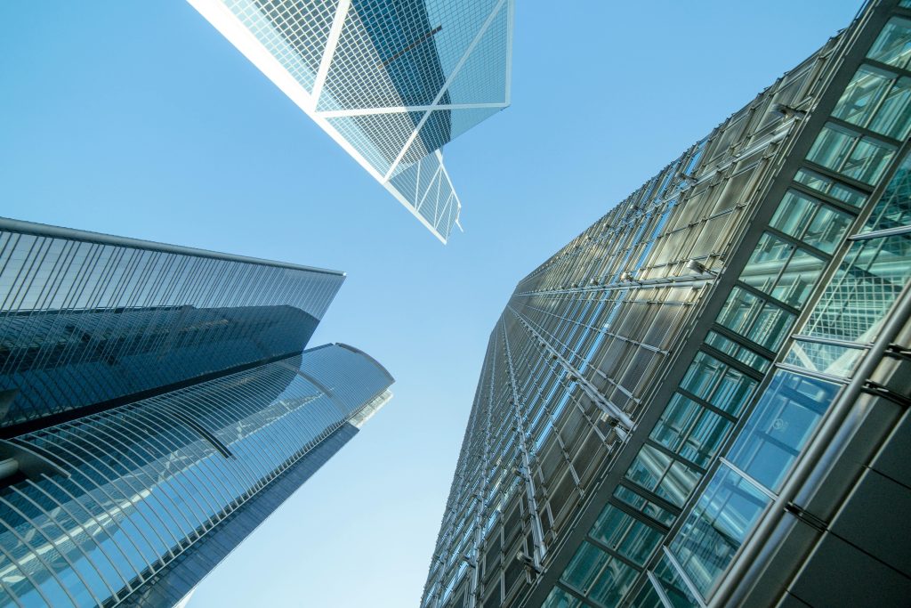 image of two modern skyscrapers with glass facades set against a clear blue sky.